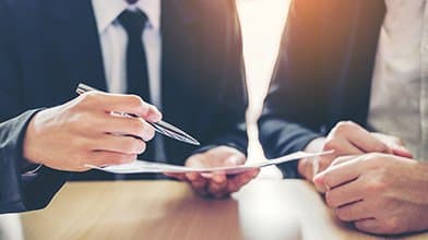 Deux personnes signant un contrat lors d'un rendez-vous d'affaires